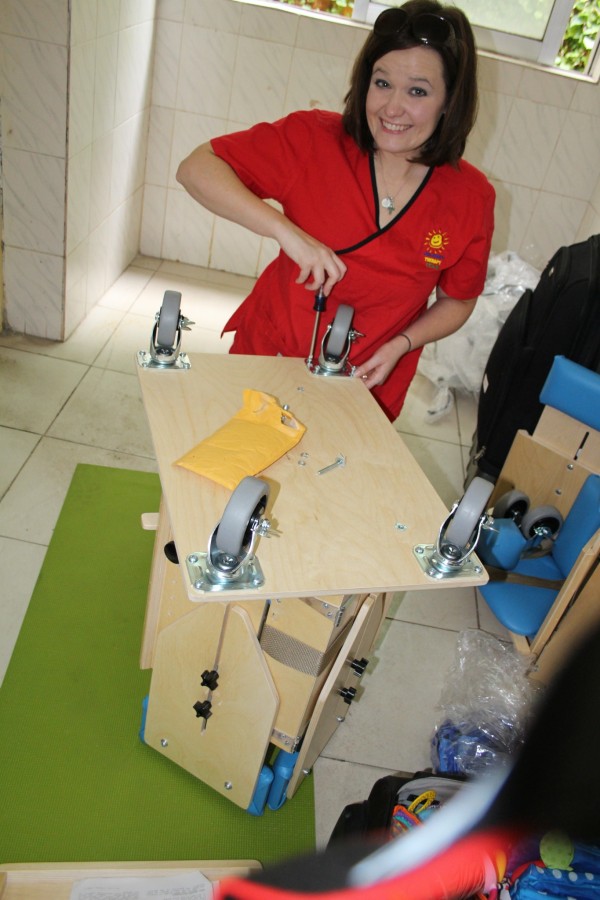 Julie assembling the corner chairs that helped the children be in safer positions for feeding.